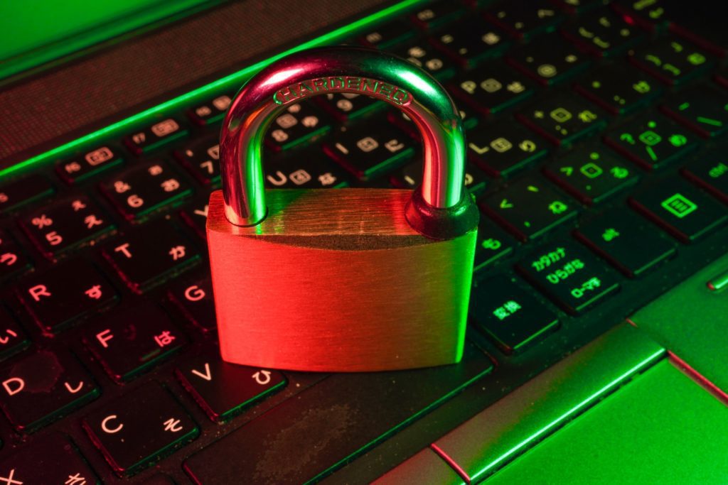 Padlock resting on a laptop keyboard lit in red and green
