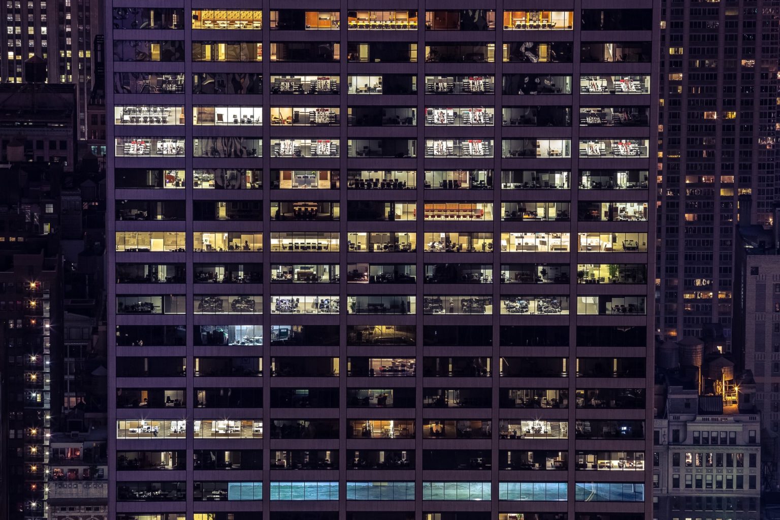 Office tower facade at night with lit floors